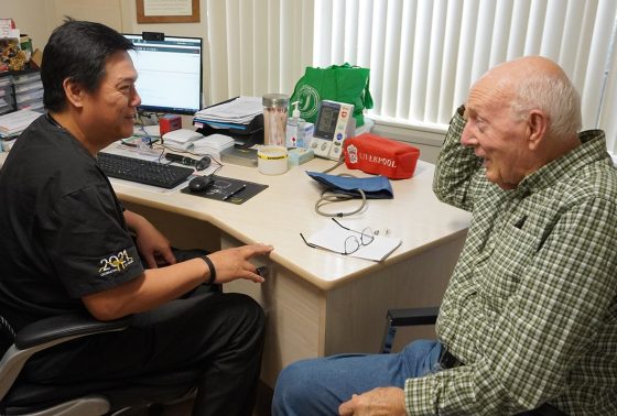 Doctor speaks to an elderly patient in a doctor room.