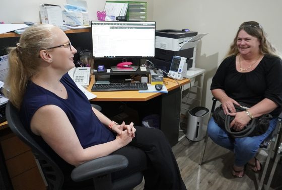 female doctor speaking to a female patient in front of a computer at a desk